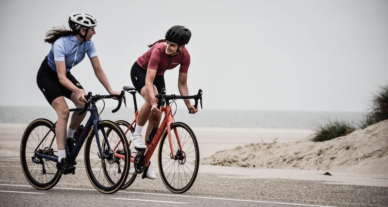 Zwei Frauen fahren Rennrad am Meer Das Rennrad ist ein beliebter Fahrradtyp für Sportler