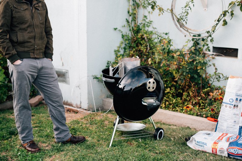 Kugelgrill-anzuenden-outdoor Mann beim anzünden