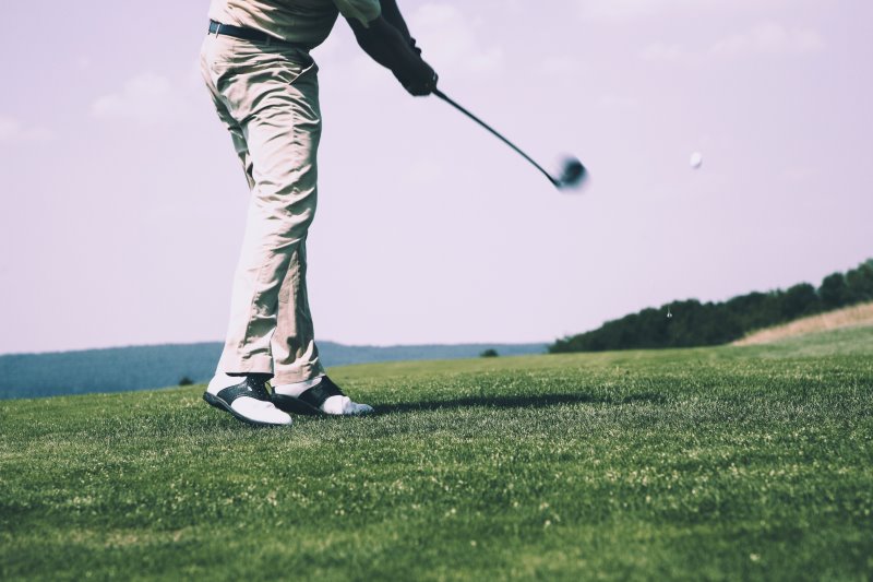 Golfer beim Abschlag golfen mit einer golfuhr