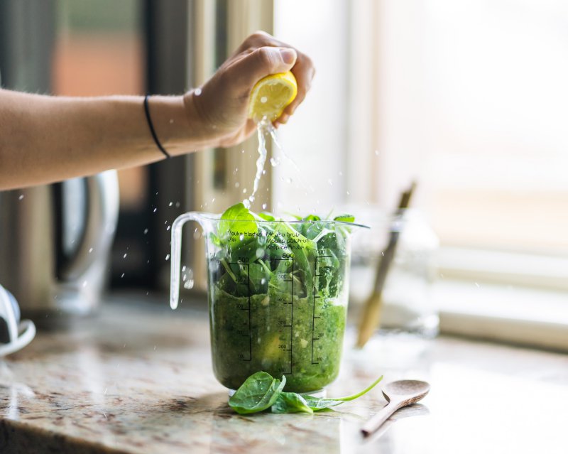 Zutaten für einen Green Smoothie in einem Mix-Behälter. Selbstgemachte Smoothies Anleitung