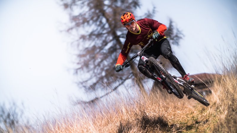 Trailbike-Fahrer der einen Berg runter fährt Trailbike-Fahrer der einen Berg runter fährt