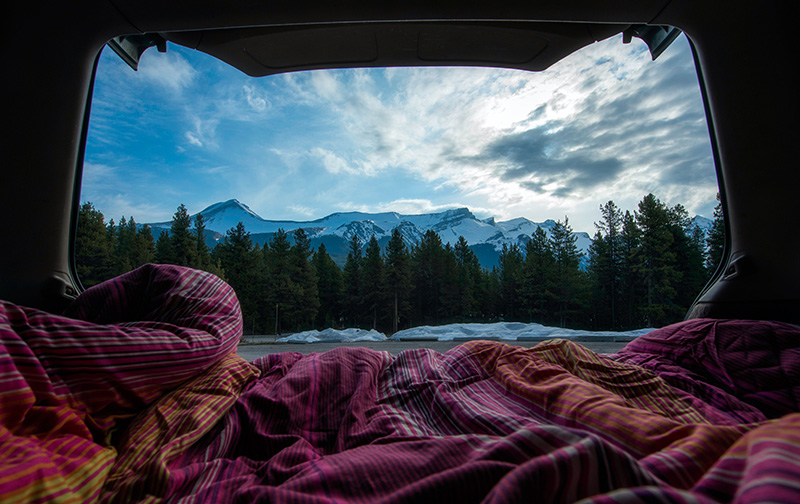 Deckenschlafsack im Auto mit Blick auf Berge