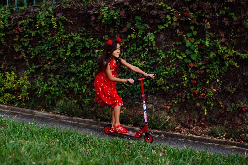 kleines Mädchen fährt Kinderroller Kinderroller: Spaß beim Fahren