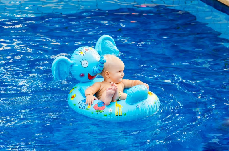 Ein Baby sitzt in einem kleinen Kinderschlauchboot mit dem Design eines Elefanten