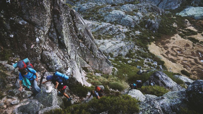 Wanderer mit Tourenrucksack auf Klettersteig Klettertour mit Tourenrucksack