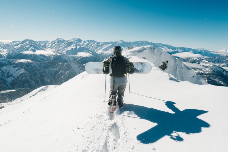 Person läuft durch Schnee Lawinenpiepser und LVS-Geraet beim Freeride