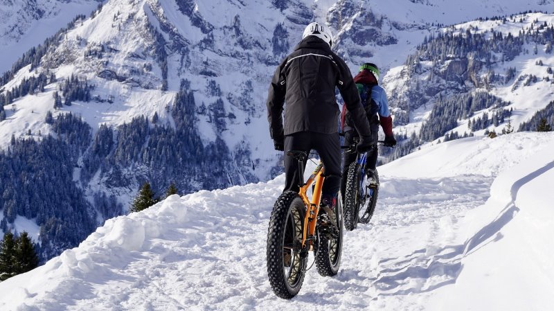 Person auf einem Fahrrad in Skihose und Skijacke