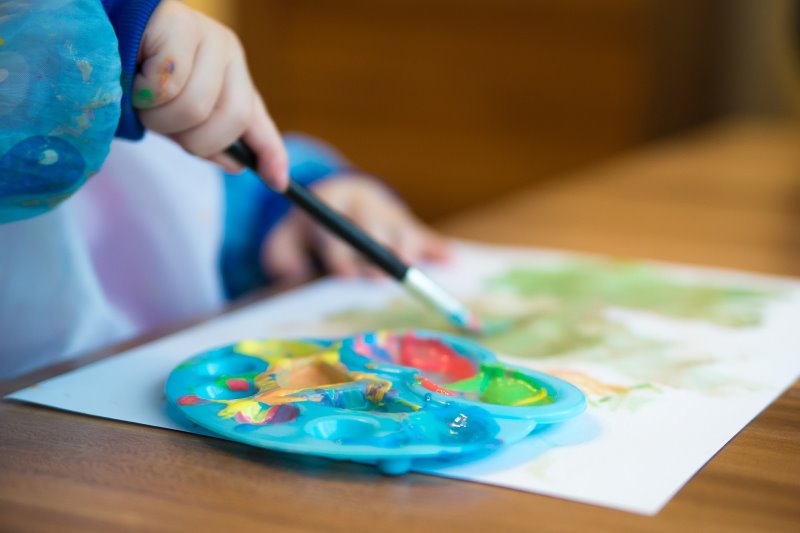 Kind malt mit Acrylfarben