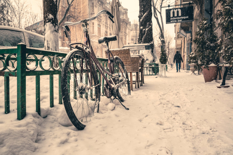 Auf einer verschneiten Straße steht ein Fahrrad angelehnt. Nabenschaltung bei Schnee