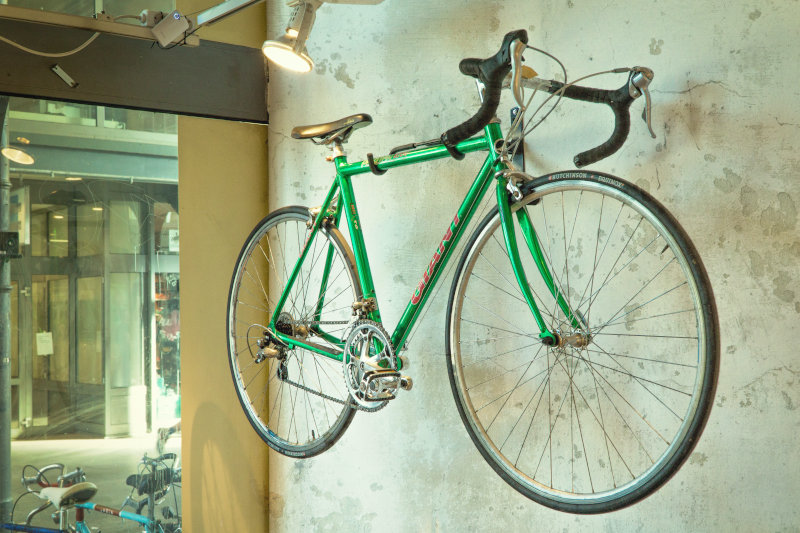 Ein grünes Sportrad häng an einer Wandhalterung Ein Fahrrad hängt an einer Wandhalterung