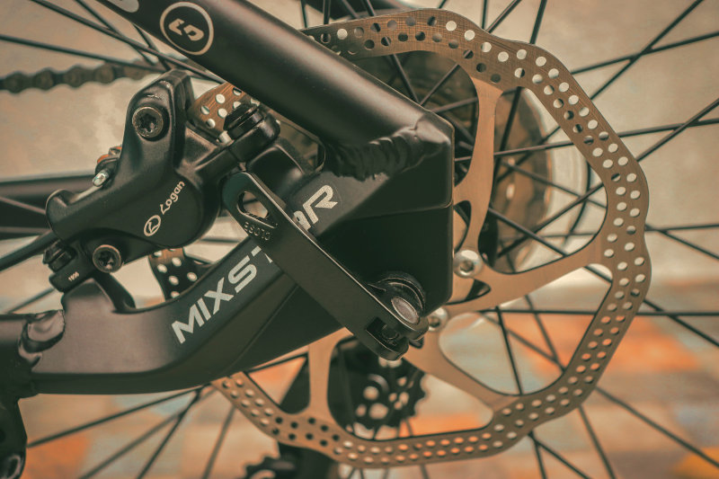 Abgebildete Scheibenbremse, womöglich eines Mountainbikes oder E-Bikes. Die Nabe ist mit einer Nebenschaltung ausgestattet. Scheibenbremse an der Nabe