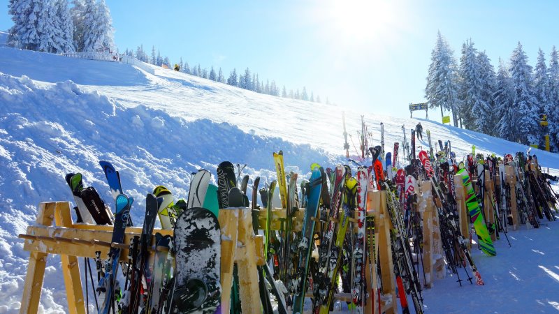 Ski und Snowboards in Reihe aufgestellt Ski und Snowboards