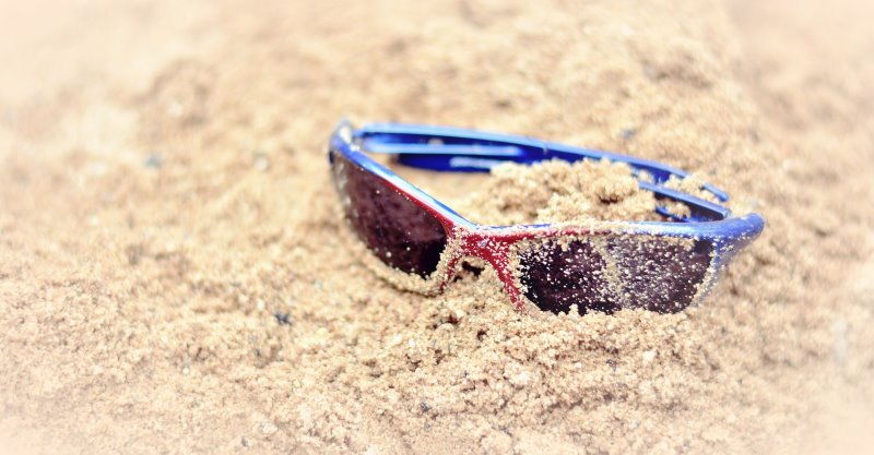 Surfer-Sonnenbrille liegt im Sand
