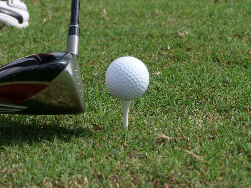 Golfschläger beim Abschlag ein Golfschläger hinter einem Golfball