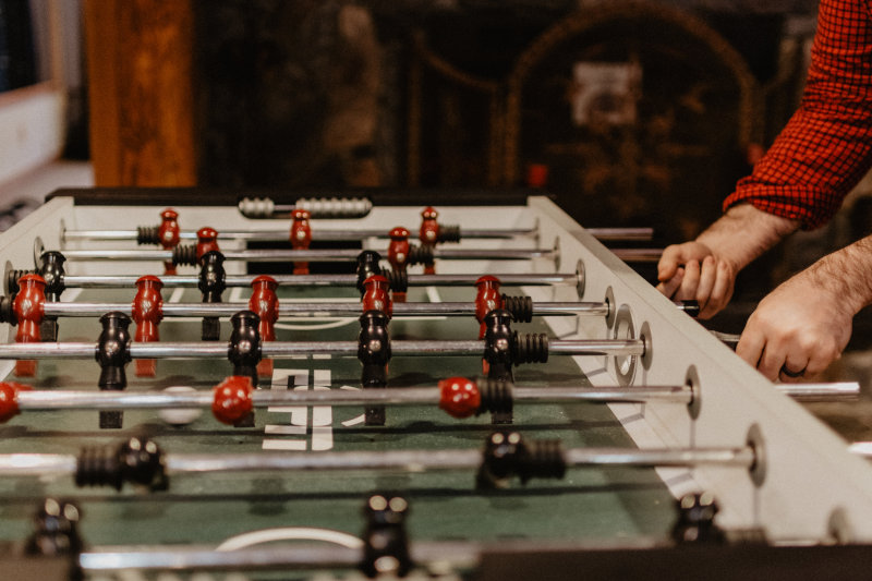 Mann spielt Tischkicker Person spielt Tischkicker