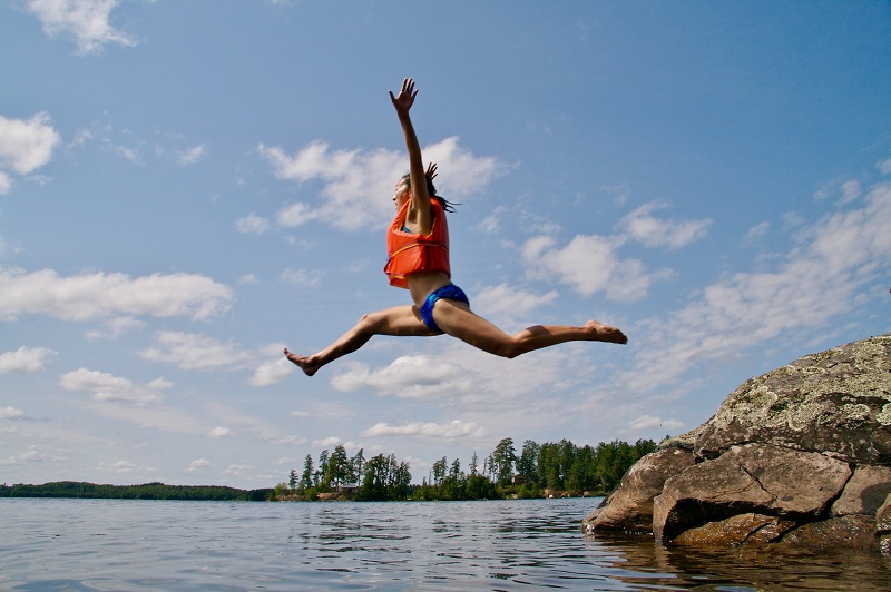 Eine springende Frau mit Schwimmweste Schwimmwesten im Test