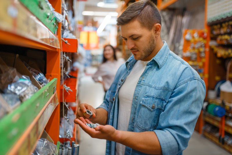 Kurbelabzieher im Baumarkt kaufen Mann sucht im Baumarkt nach dem richtigen Werkzeug