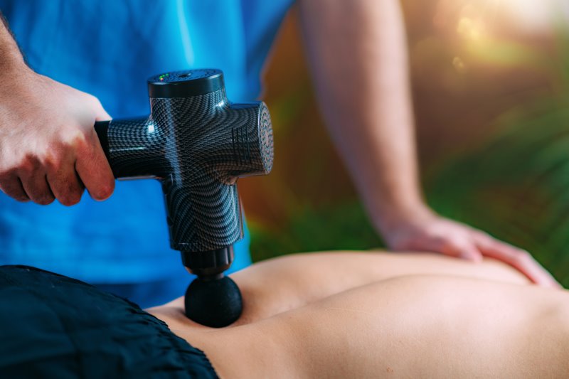 Rückenmassage mit Massagepistole