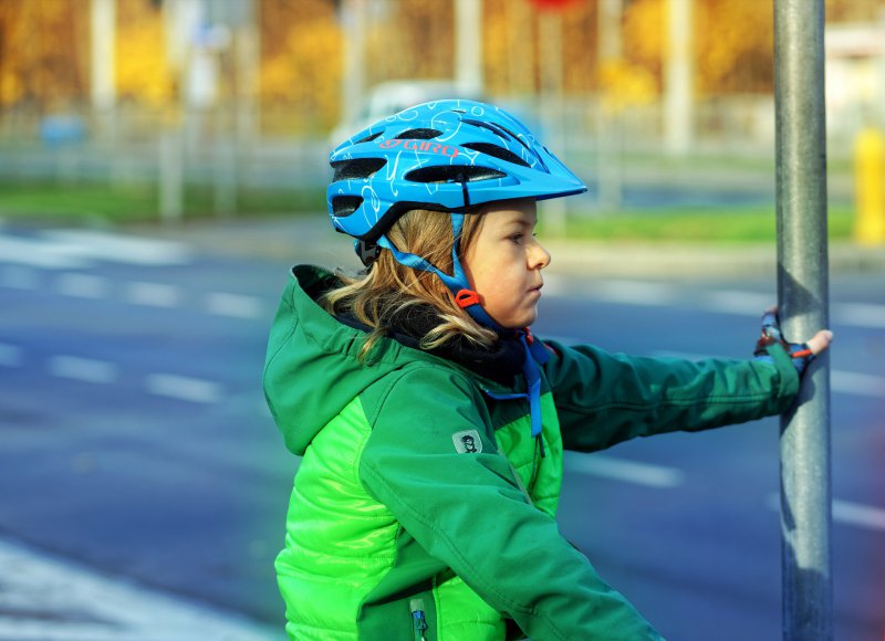 Ein Kind mit einer Fahrradjacke auf dem Fahrrad