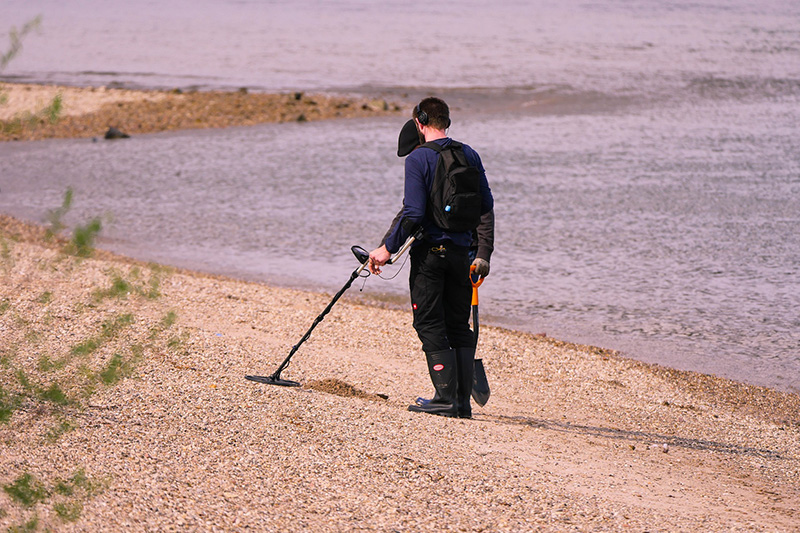 Metalldetektor am Strand. Sondengänger mit Metalldetektor