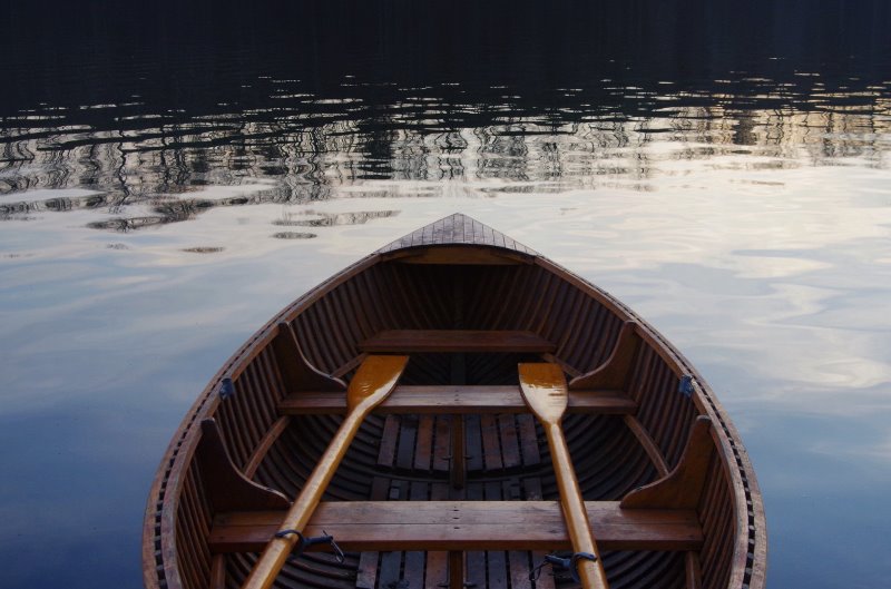 Paddelboot mit Holzpaddel Paddelboot aus Holz mit einem Paar Stechpaddel