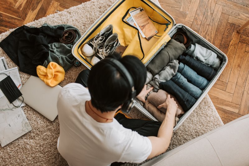 Mann pack Kleidung ein Koffer packen