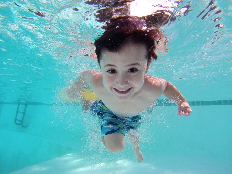 Einwegkamera im Test: Einweg-Unterwasserkamera Ein Kind im Pool schaut in die Linse einer Unterwasserkamera.