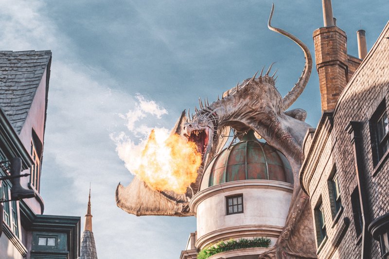 Drache Ein Drache sitzt auf einem Gebäude und speit Feuer.