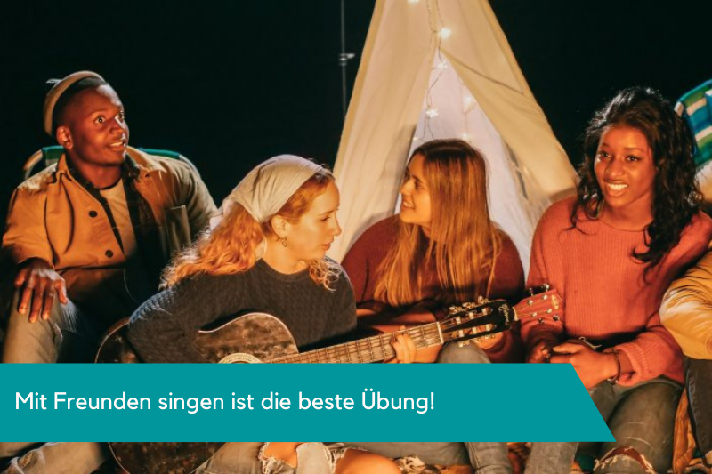 Singen lernen mit Freunden am Lagerfeuer