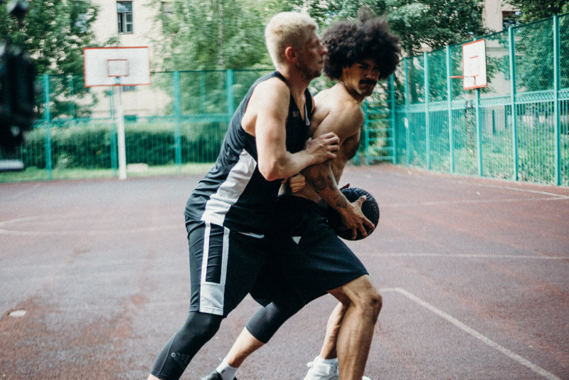 Ein Streetballspieler versucht den anderen zu Blocken.
