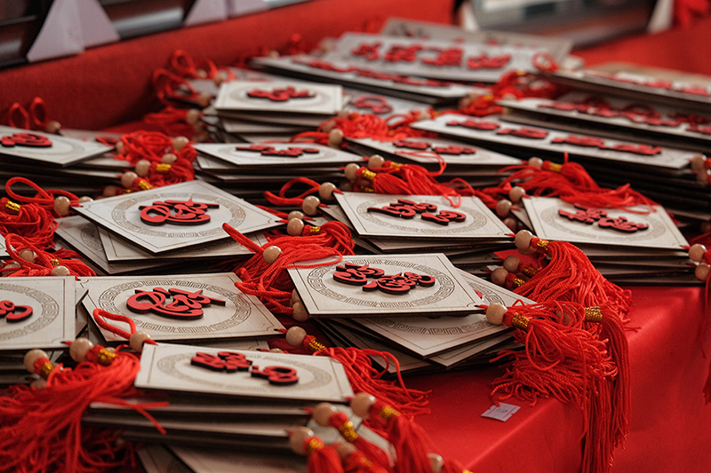 Eine Reihe an chinesischen Aufhängern liegt auf einem Tisch verteilt. Die rote Farbe dominiert.