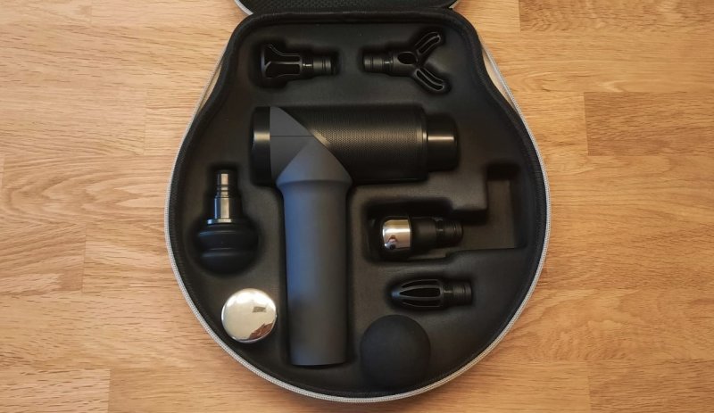 Die geöffnete Tasche Der OrthoMechanik Massagepistole, samt Inhalt.