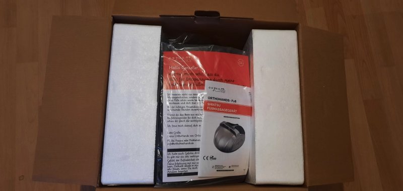 Erstmalig geöffnete Verpackung des Fußmassagegeräts von OrthoHands.