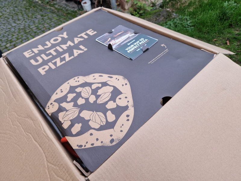 Verpackung des Pizzaofens mit Pizza-Guide.